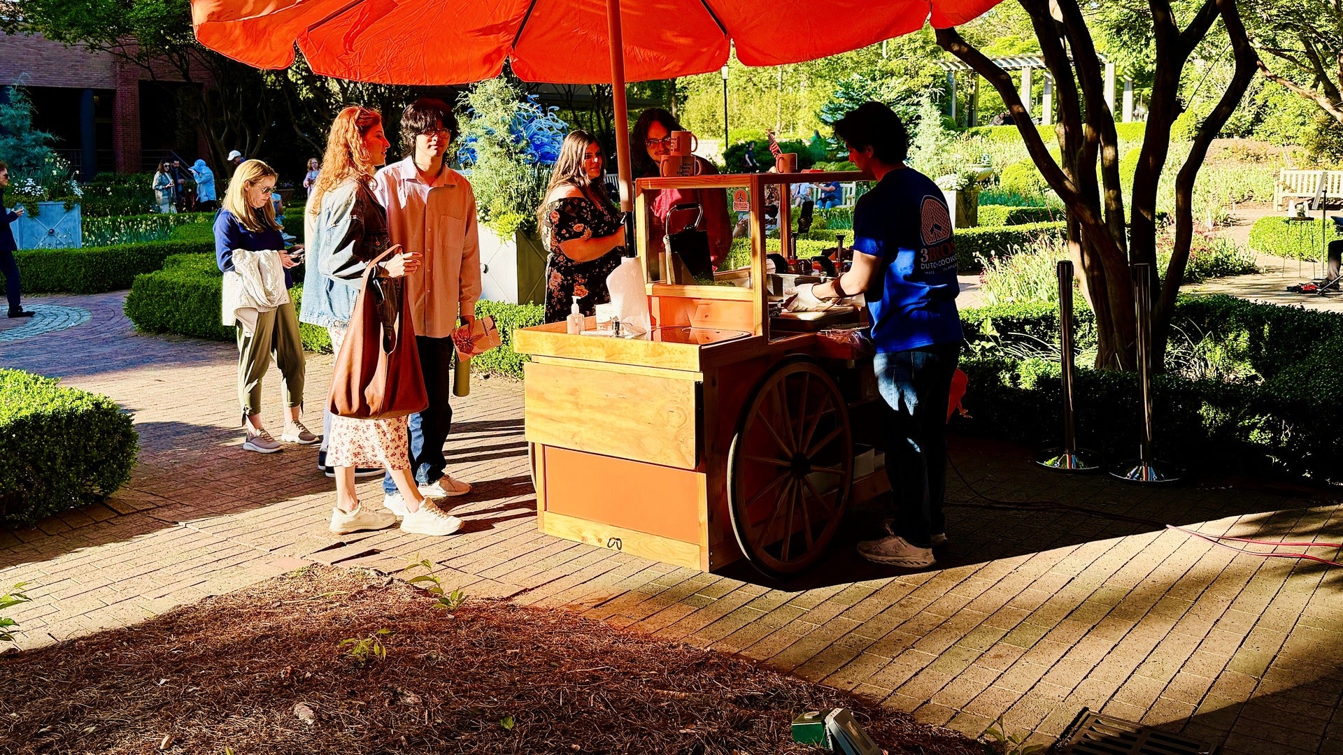 The 3 Bros baking cart in service, baking fresh stroopwafels for a line of customers