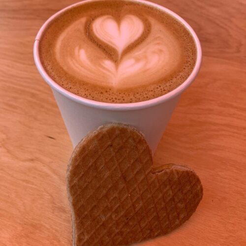 A heart-shaped Stroopwafel and cappucino with a heart